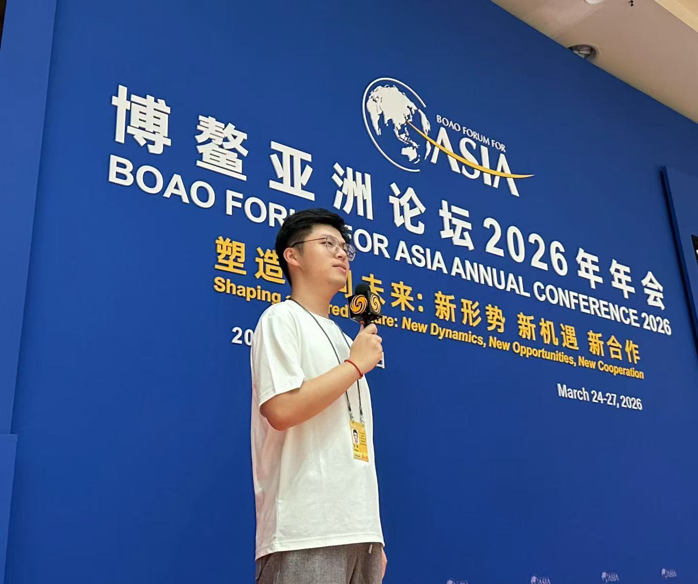 余鎵馳在博鰲亞洲論壇現場持鳳凰衛視話筒報道